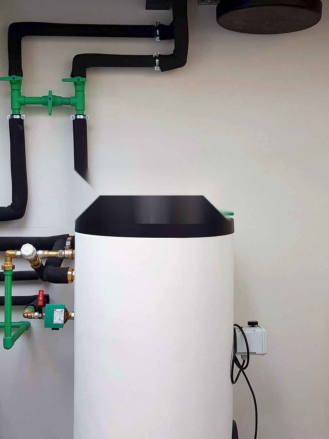 Acumulador de agua caliente con sus tuberías aisladas en una sala de máquinas, instalación nuestra en Mallorca