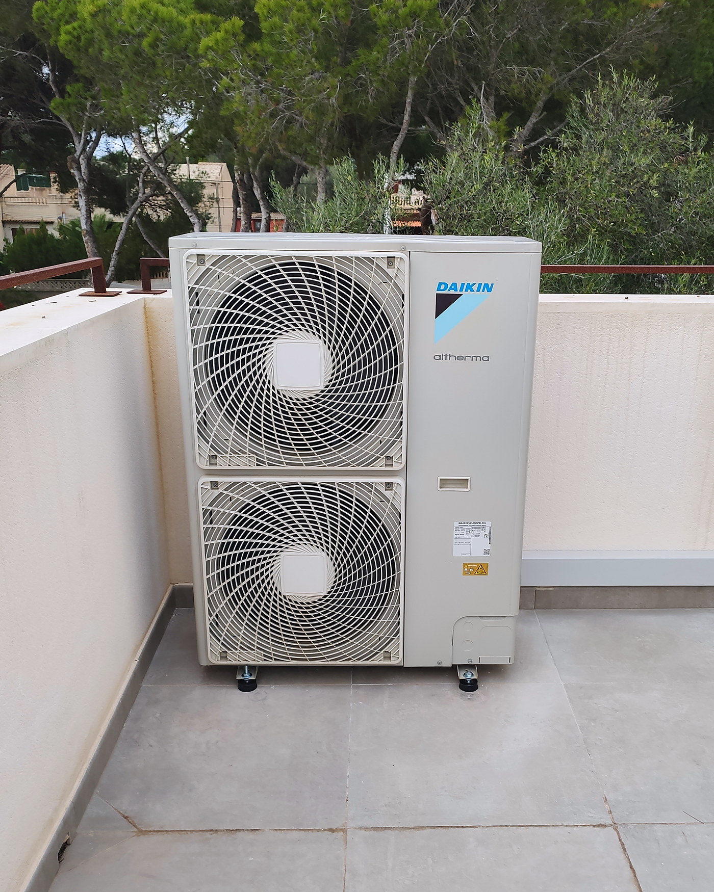 Bomba de calor instalada por JSL en la terraza de una vivienda en Mallorca, entre pinos