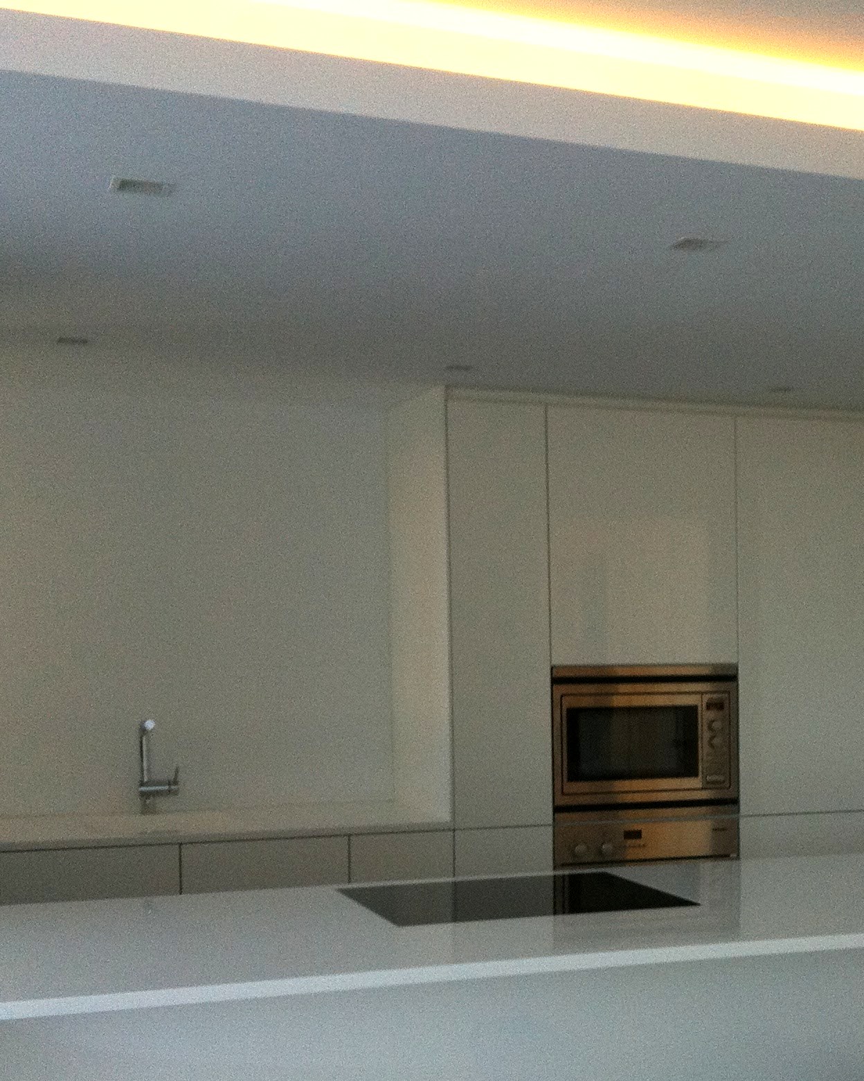 Cocina terminada con la rejilla de climatización por conductos integrada en el techo, en una vivienda de Mallorca