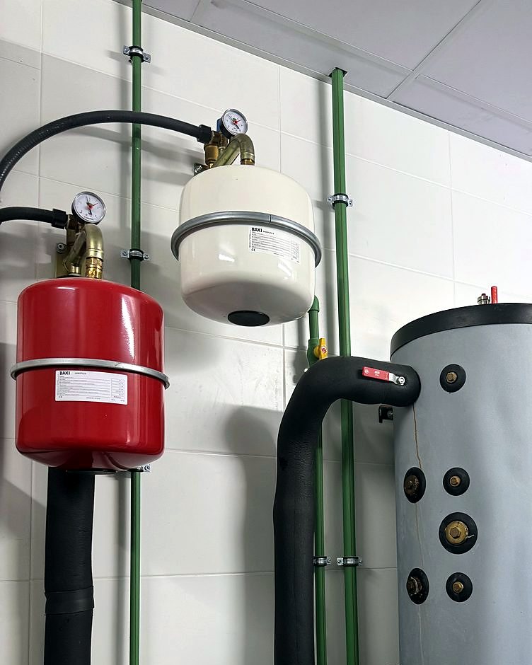 Depósito de agua caliente y vasos de expansión de una instalación de aerotermia en la sala técnica de una vivienda de Mallorca, montada por JSL