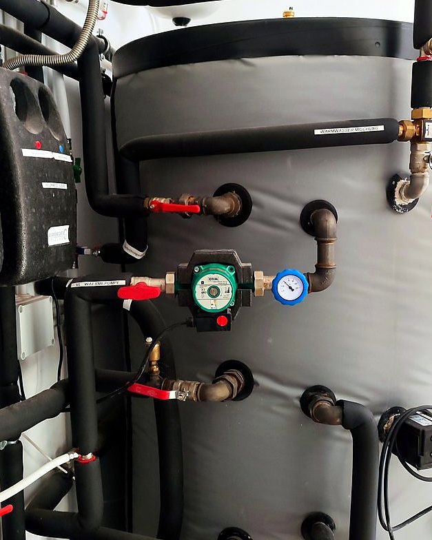 Depósito de inercia de una aerotermia con su bomba circuladora, las llaves y la tubería aislada, montado por JSL en Mallorca