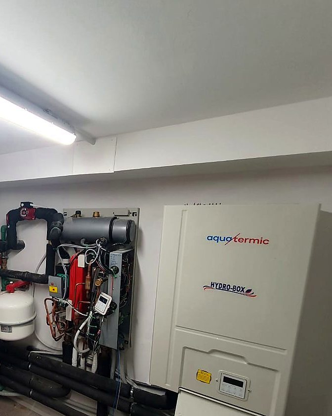 Sala técnica de aerotermia con el módulo hidráulico abierto durante la puesta en marcha, su vaso de expansión y la tubería aislada, en una obra de JSL en Mallorca