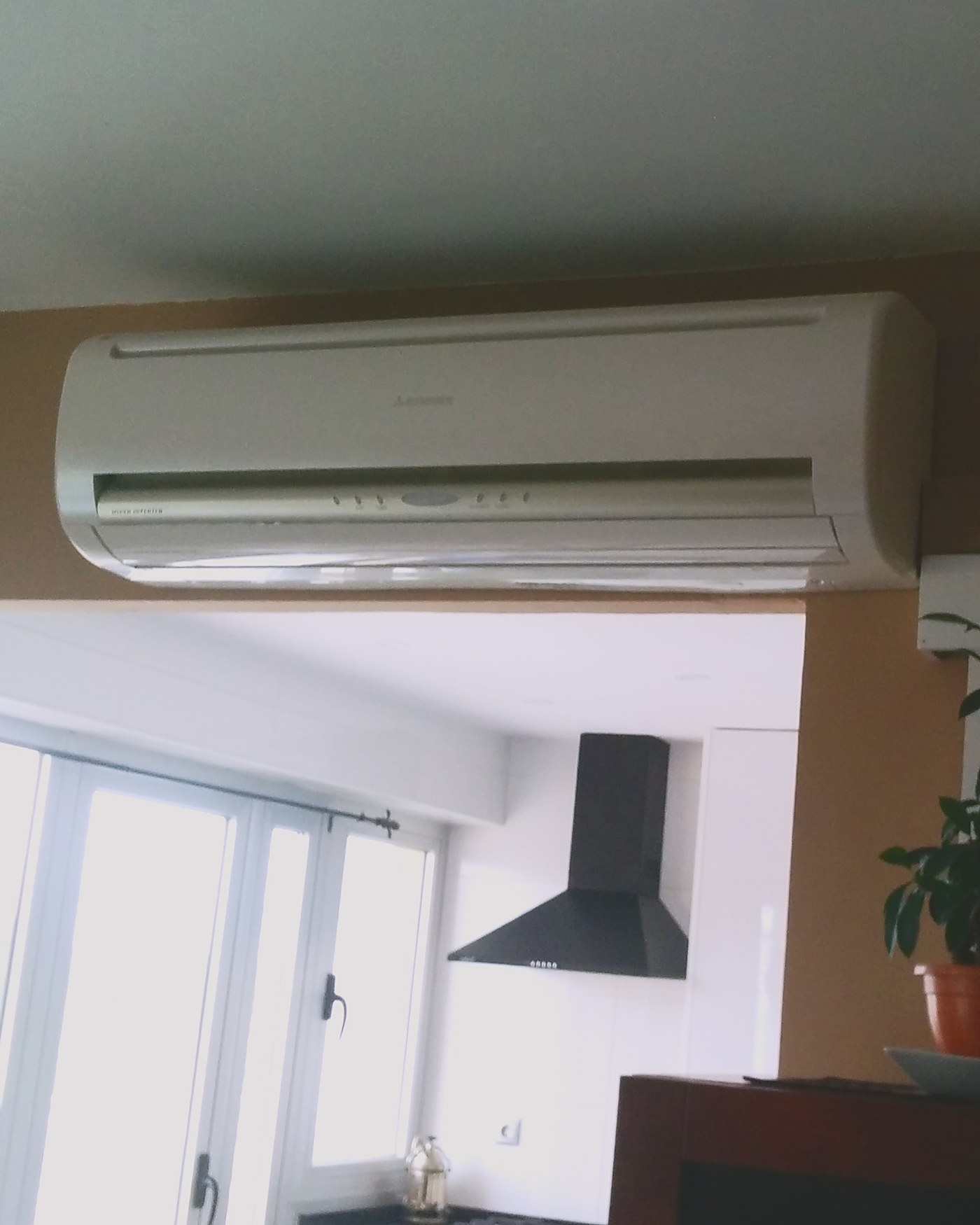 Split de pared en un salón abierto a la cocina, instalado por JSL en una vivienda de Mallorca