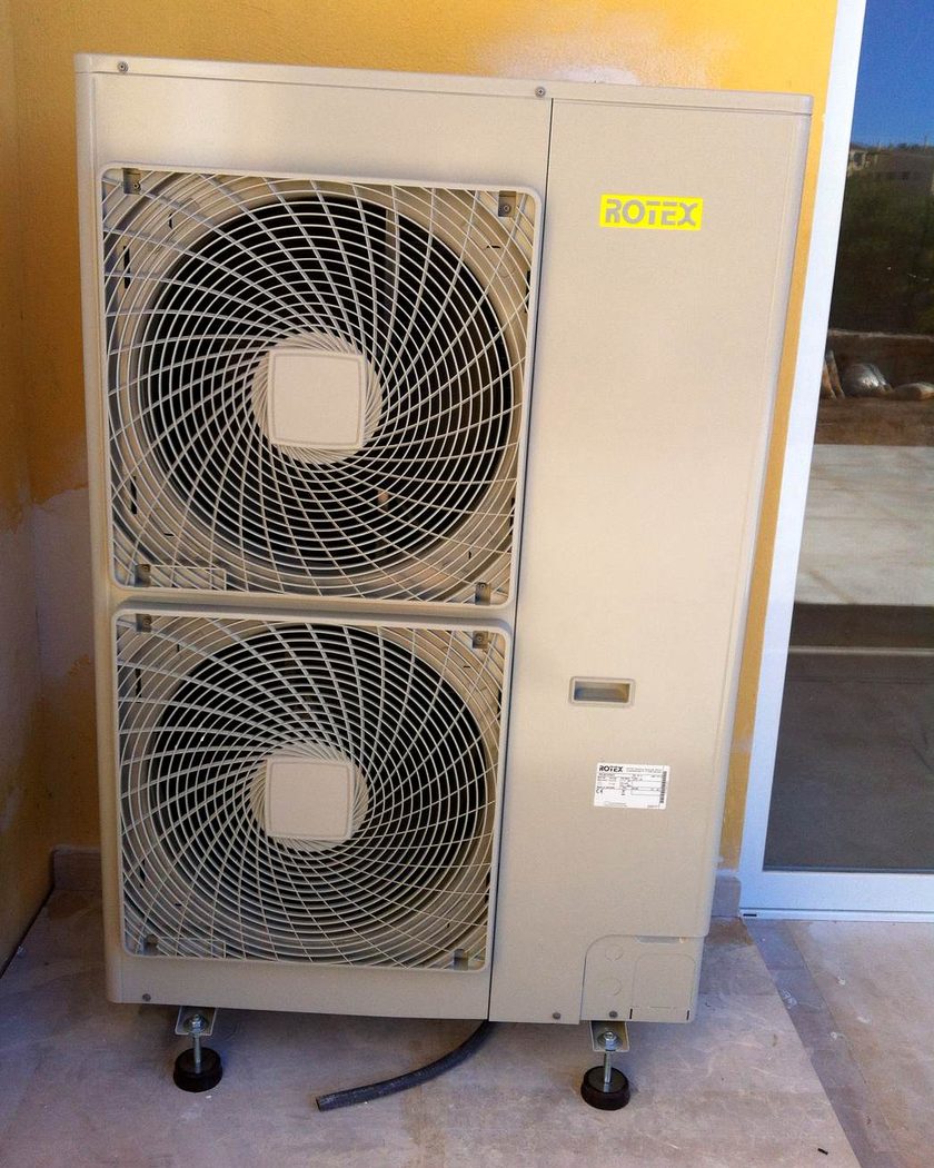 Unidad exterior de bomba de calor Rotex sobre soportes antivibratorios en el porche de una vivienda de Mallorca, instalada por JSL