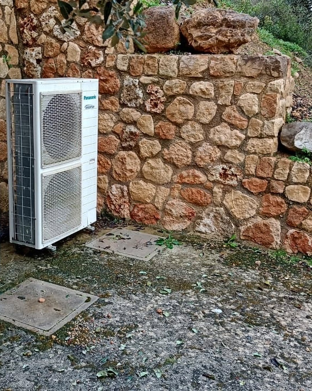 Dos unidades exteriores de bomba de calor junto a un muro de piedra seca en una finca de Mallorca