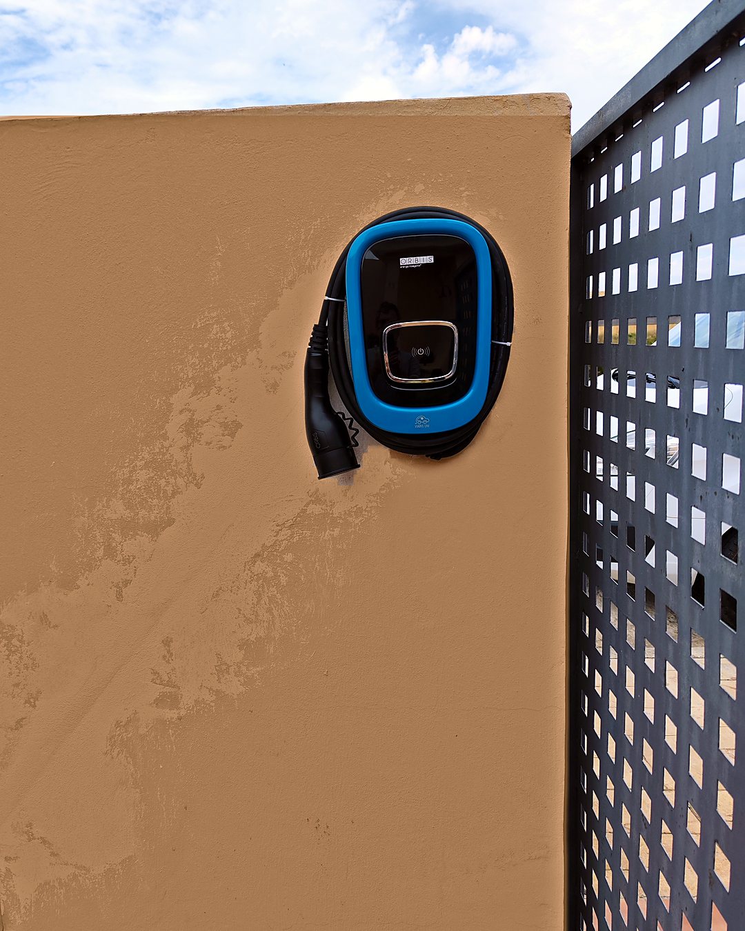 ORBIS Viaris EV charger with its cable, installed by JSL on the outside wall of a house in Mallorca
