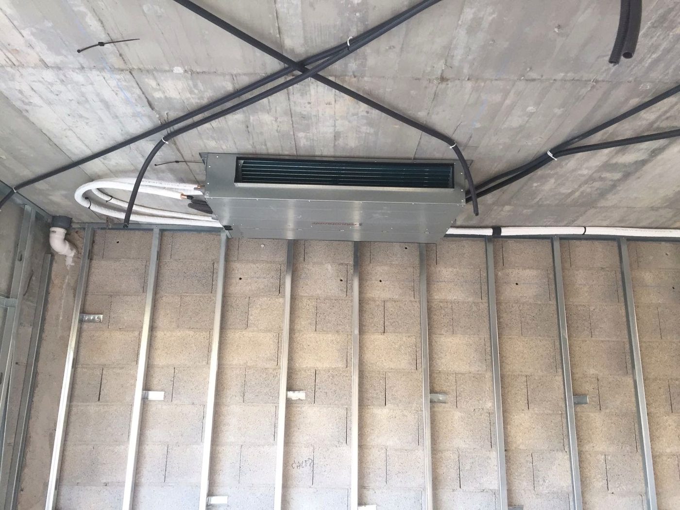Refrigerant lines arriving at the air-conditioning unit during the Casa Llucmajor build, an installation by JSL in Mallorca
