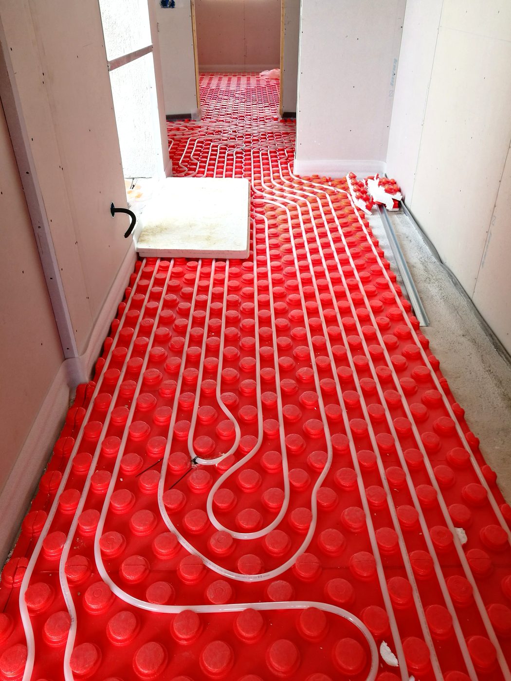 Exposed PEX underfloor-heating pipe in the hallway during the Casa Llucmajor build, an installation by JSL in Mallorca