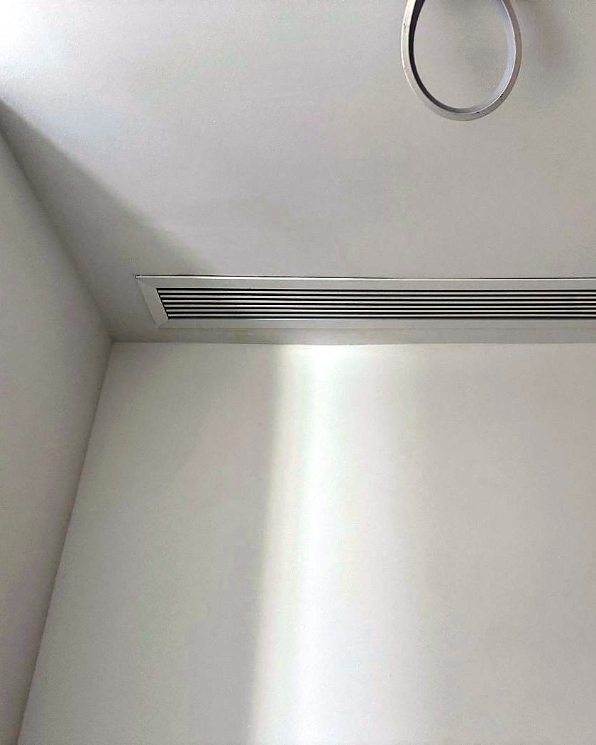 Rejilla lineal de aire acondicionado por conductos enrasada en el techo de una habitación, montada por JSL en Mallorca