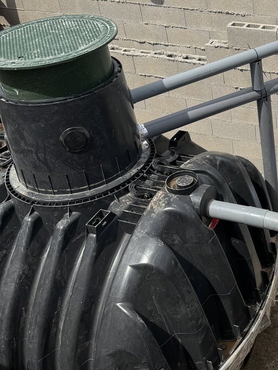 Depósito de polietileno de una depuradora con su cuello de registro y la tapa verde, ya conectado, montado por JSL en Mallorca