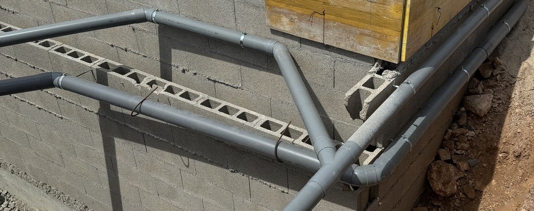 Tuberías de PVC fijadas al muro que llevan las aguas de la casa hasta los depósitos de la depuradora, montadas por JSL en Mallorca