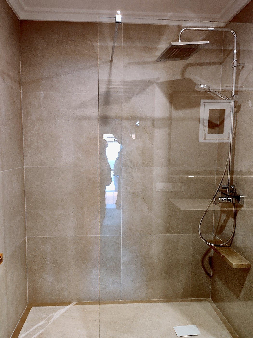 Shower with overhead rain head, glass screen and thermostatic mixer, one of our installations in Mallorca
