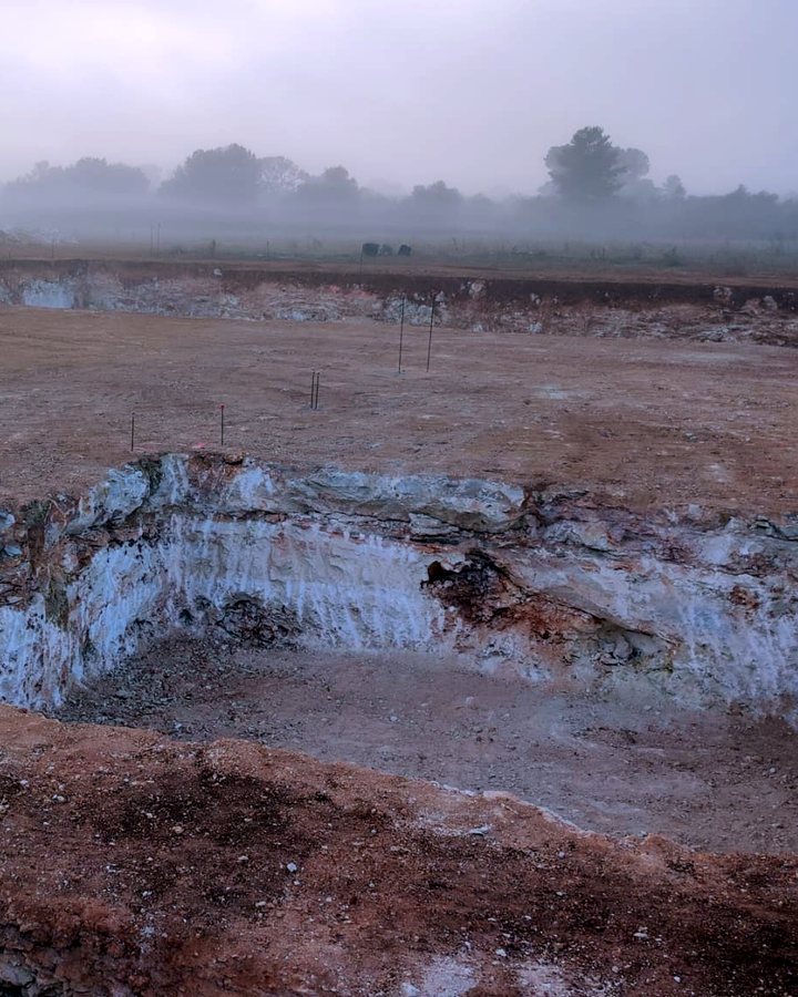Excavación abierta en roca caliza bajo la tierra roja, en una parcela rústica de Mallorca