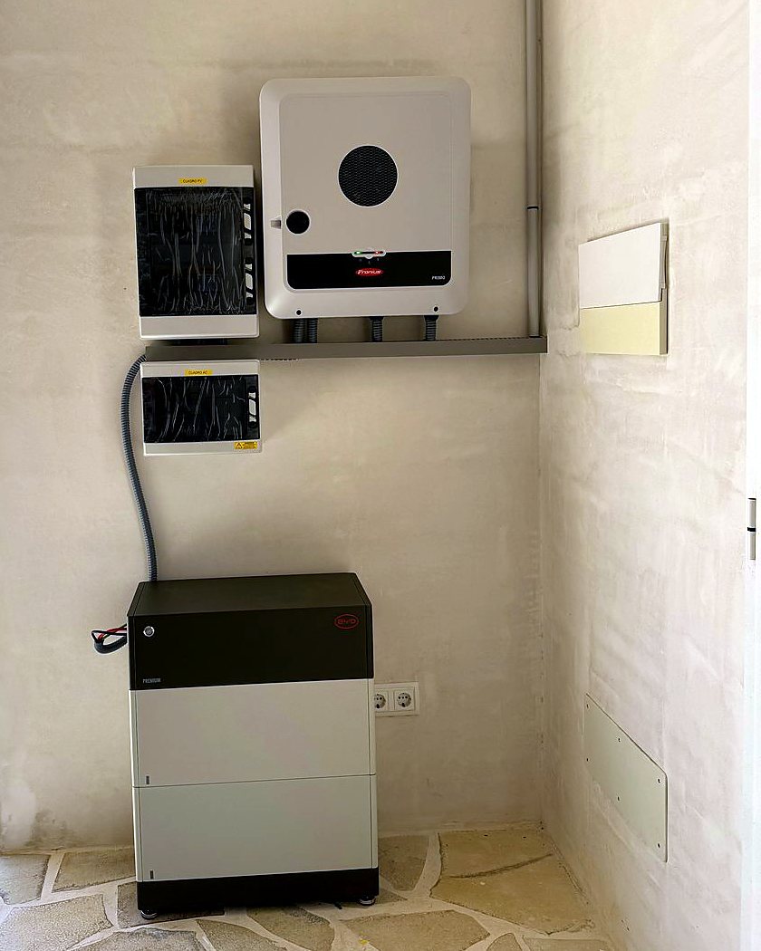 Inversor Fronius con su batería en el suelo y los cuadros de protección, en el porche de una casa de marés, montado por JSL en Mallorca