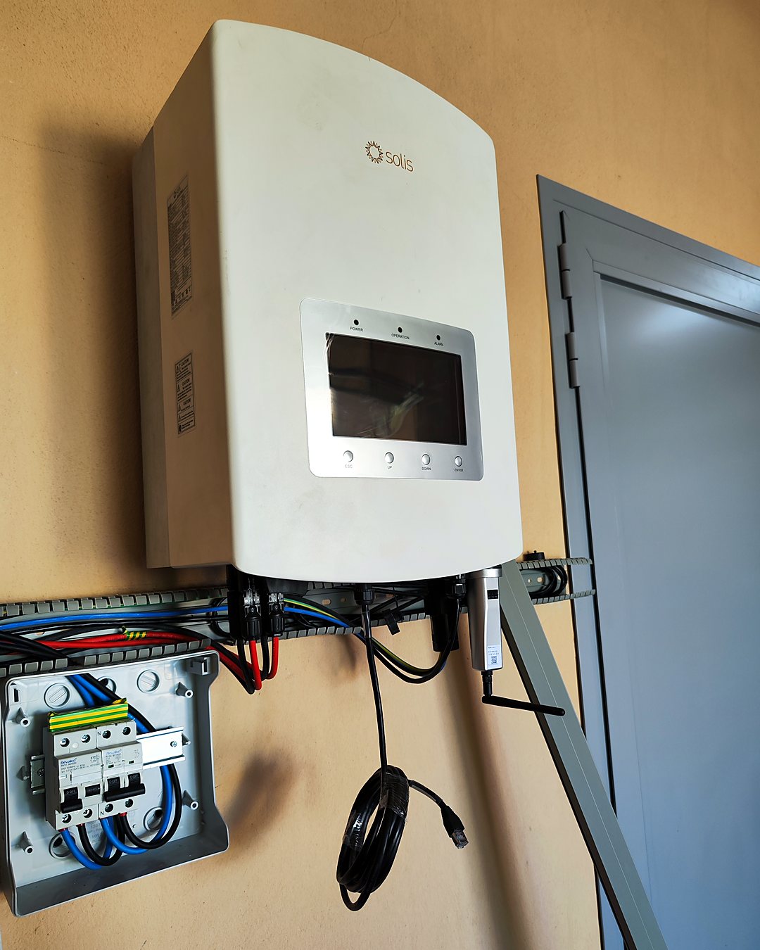 Inversor fotovoltaico Solis y cuadro de protecciones montados por JSL junto a la puerta de una vivienda de Mallorca