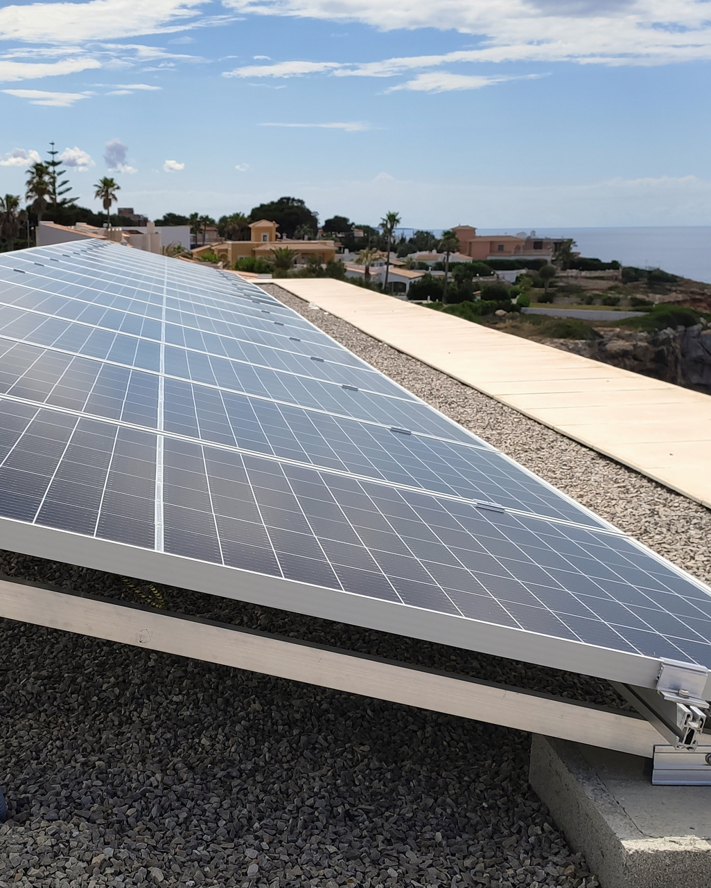 Placas solares instaladas por JSL sobre la azotea de una vivienda de Llucmajor, con el mar al fondo