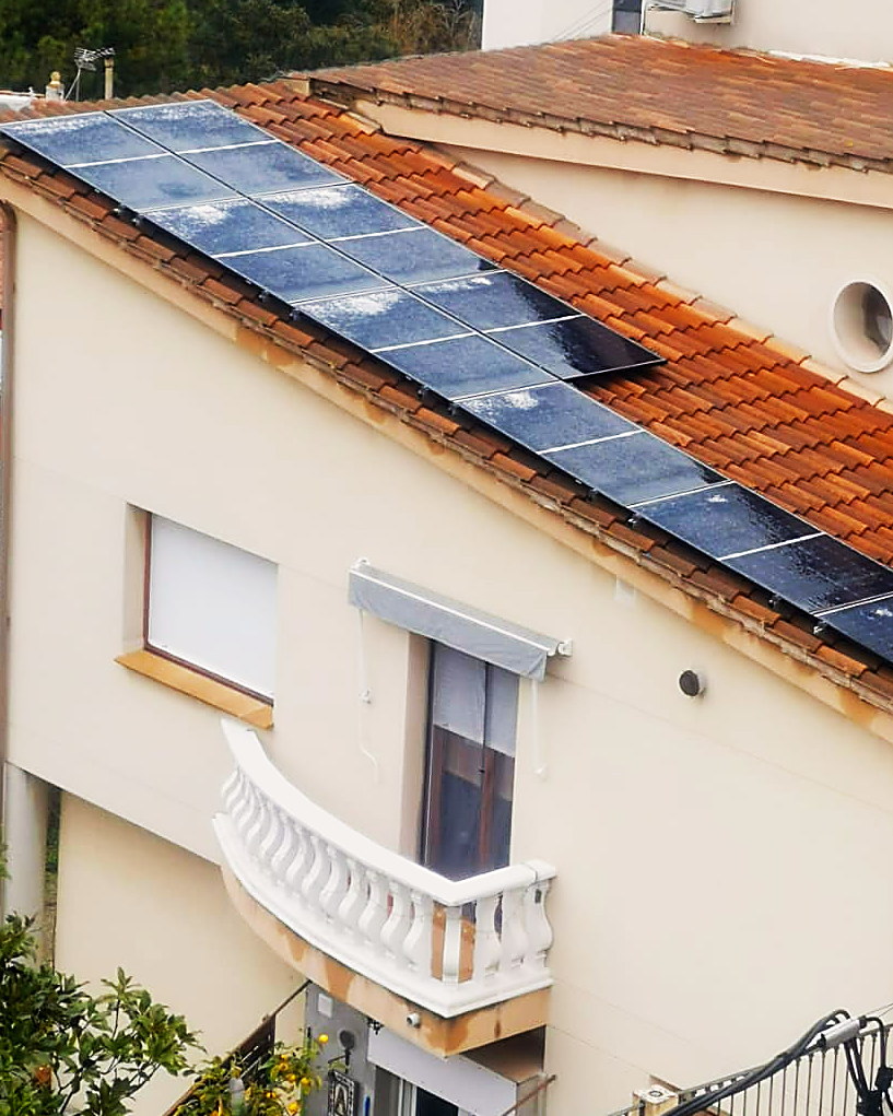 Placas solares en el tejado de teja de una casa con balcón, una instalación nuestra en Mallorca