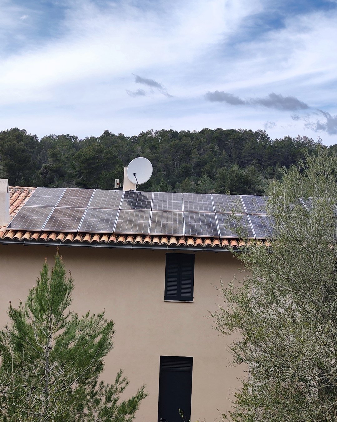 Casa de campo entre pinos y olivos con placas solares en el tejado de teja, una instalación de JSL en Mallorca