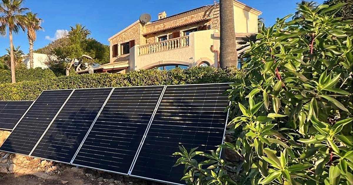 Placas solares en el jardín de una villa de costa, con la casa al fondo: una instalación nuestra en Mallorca