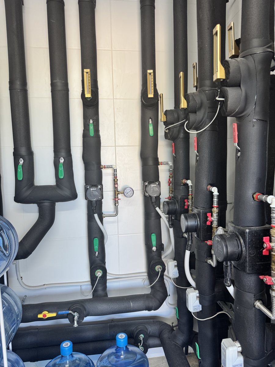 Sala de máquinas con colectores y circuladores de aerotermia y suelo radiante instalada por JSL en Mallorca