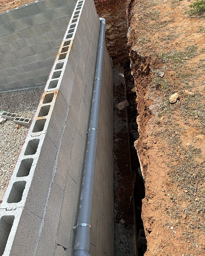 Canalización de PVC hacia la depuradora al pie del muro de bloques, en la zanja antes de rellenar, montada por JSL en Mallorca