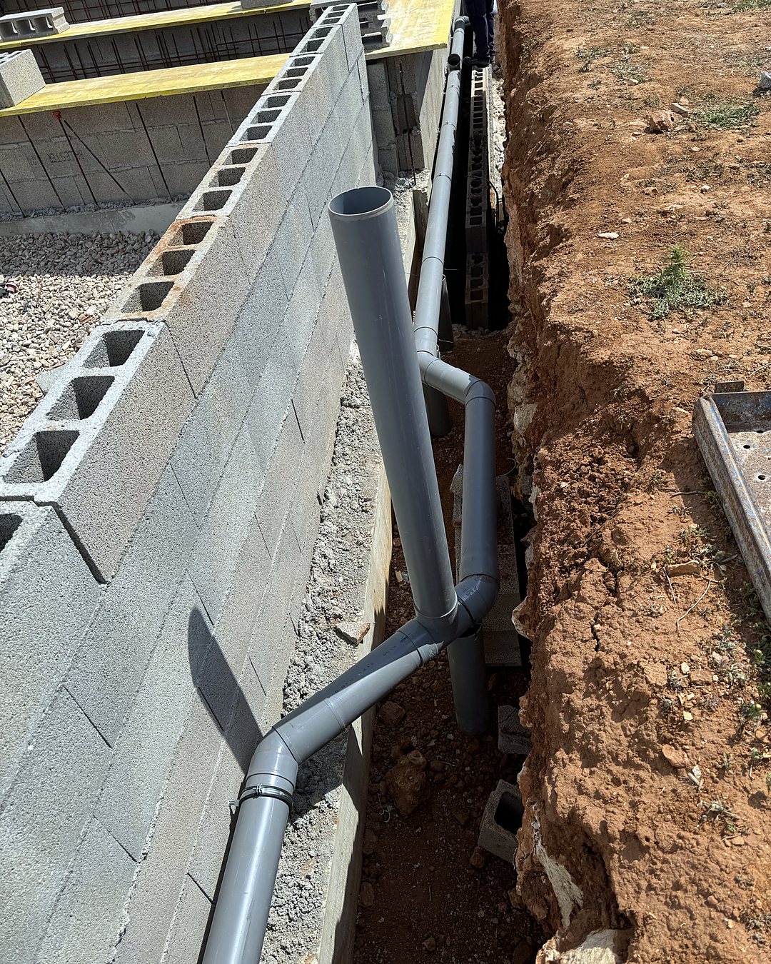 PVC drain pipe of a house running down the trench beside the block wall towards the treatment plant, fitted by JSL in Mallorca