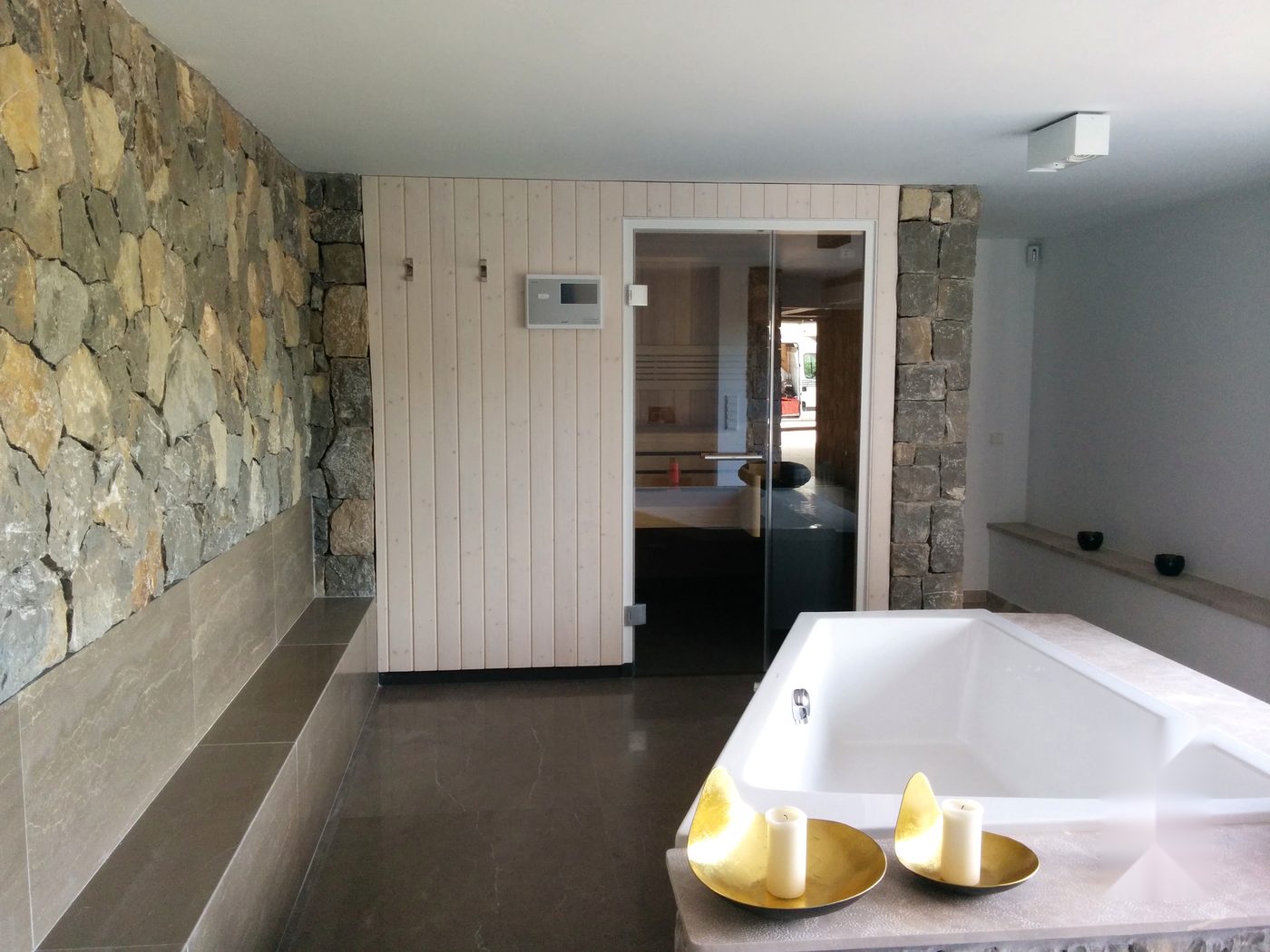 Privates Spa mit Badewanne, Steinwand und Sauna in einer Villa auf Mallorca mit JSL-Installationen