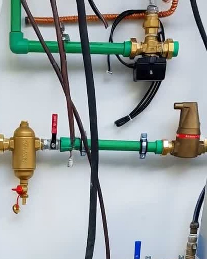 Ventile und farbig gekennzeichnete Rohrleitungen im Technikraum einer Wärmepumpenanlage in einem Haus auf Mallorca